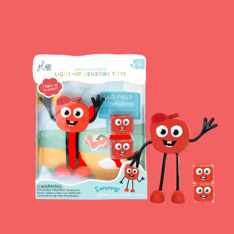 Red toy figure with googly eyes and black arms and legs next to its packaging on a white background