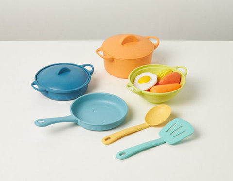 Colorful toy kitchen set with pots, pans, and utensils on a white background