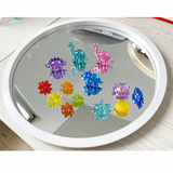 Translucent dinosaurs, leaves and sea-life counters together on a round mirror