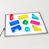 Translucent geometric shapes arranged on an A4 light panel